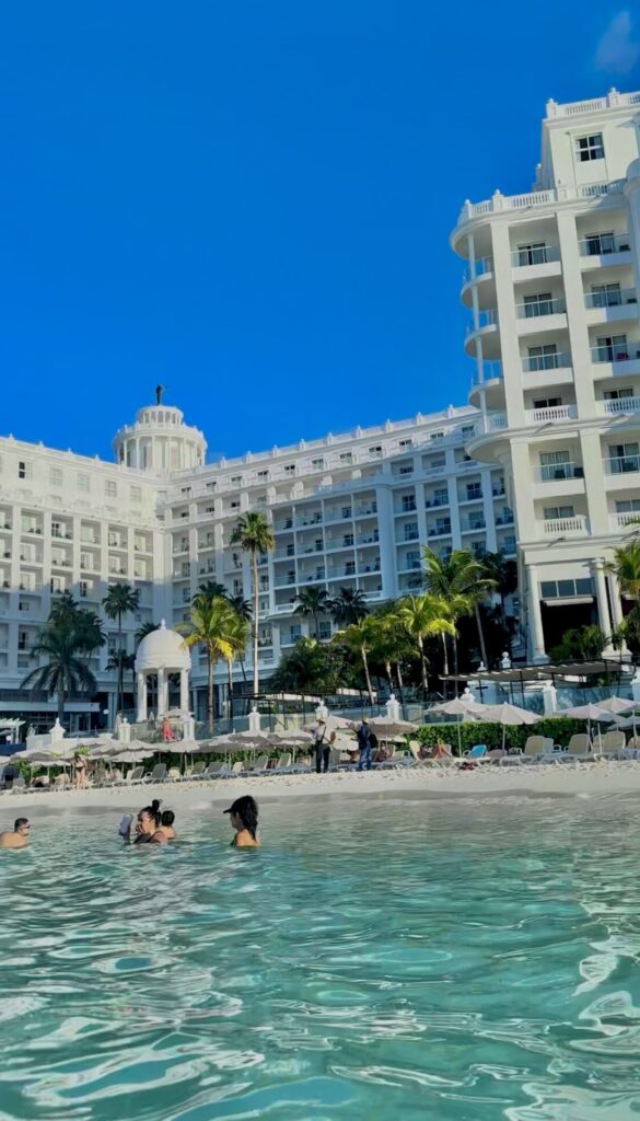 white building in the back of the image with other people in the water