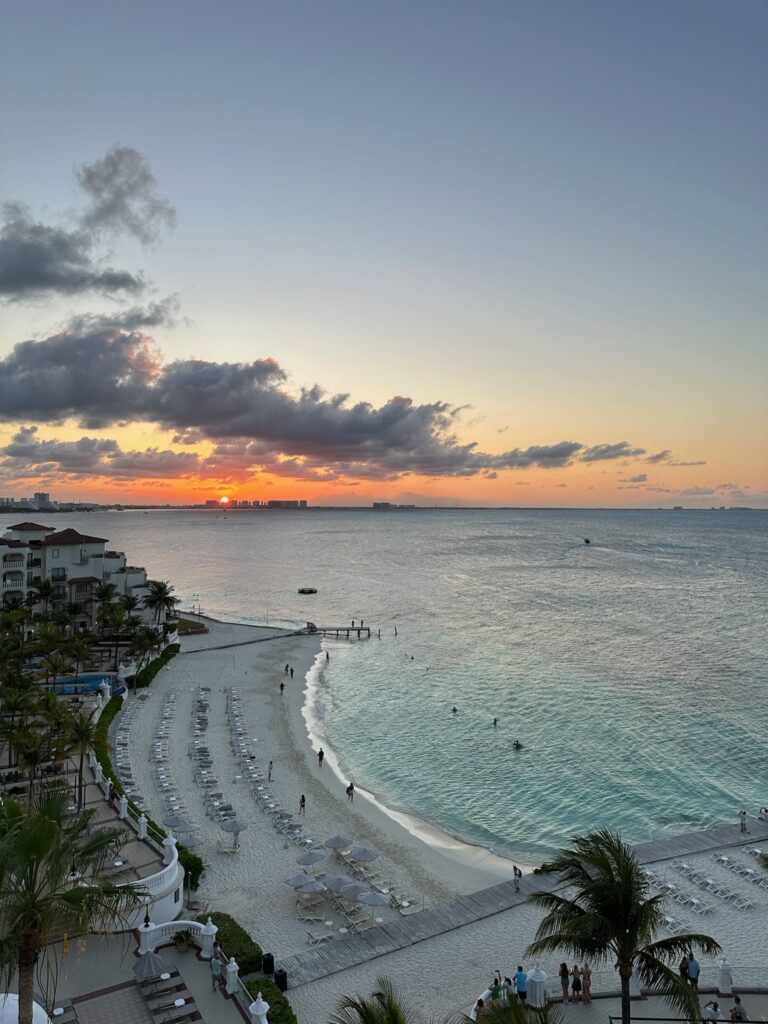 Sunset in the background with a full view of the beach and skyline in the background